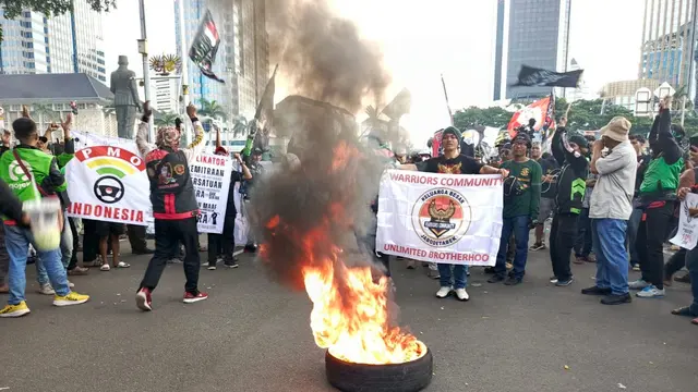 Sebagian massa demonstrasi ojek online atau ojol mulai meninggalkan kawasan Patung Kuda di sekitaran Monumen Nasional (Monas), Jakarta usai ada yang membakar ban.