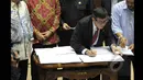 Menkumham Yasona Laoly menandatangi Perppu Pilkada dalam rapat kerja bersama Komisi II DPR di Gedung Nusantara, Kompleks Parlemen Senayan, Jakarta, Senin (19/1/2015). (Liputan6.com/Andrian M Tunay)