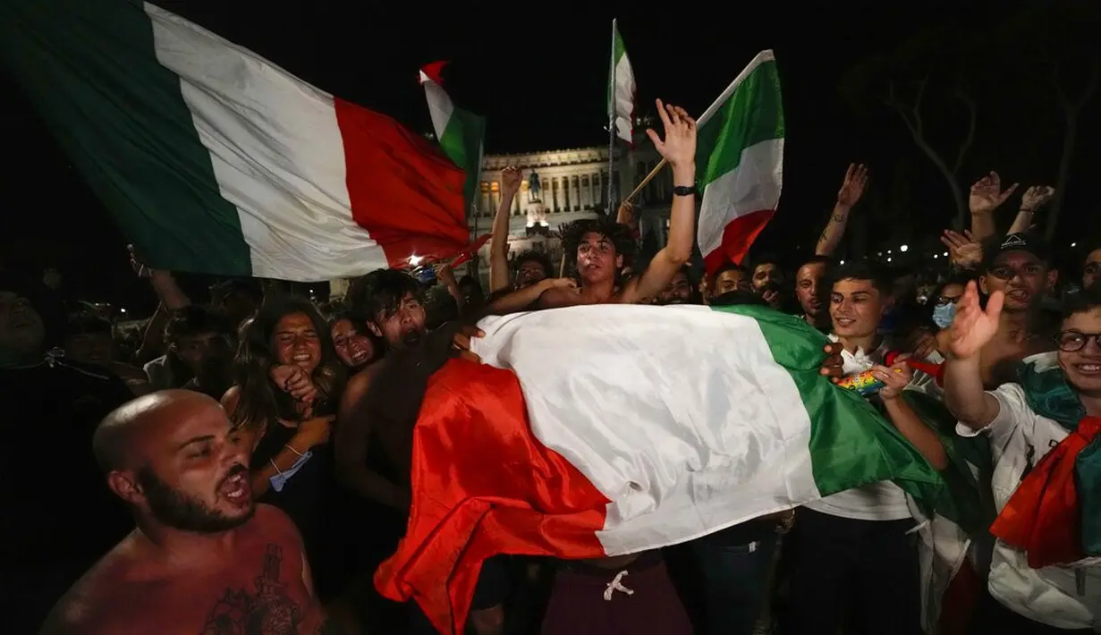 Suporter Italia merayakan kemenangan atas Spanyol pada pertandingan semifinal Euro 2020 di Roma, Rabu (7/7/2021). Italia akan bertemu antara pemenang Inggris vs Denmark di babak final. (AP Photo/Alessandra Tarantino)