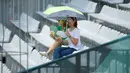 Terik Matahari membuat dua suporter menggunakan payung saat menonton tim Baseball Korea melawan tim Baseball Hong Kong pada penyisihan Baseball Asian Games 2018 di Lapangan Baseball Senayan, Jakarta (28/8). (ANTARA FOTO/INASGOC/Nick Hanoatubun/MTG/18)