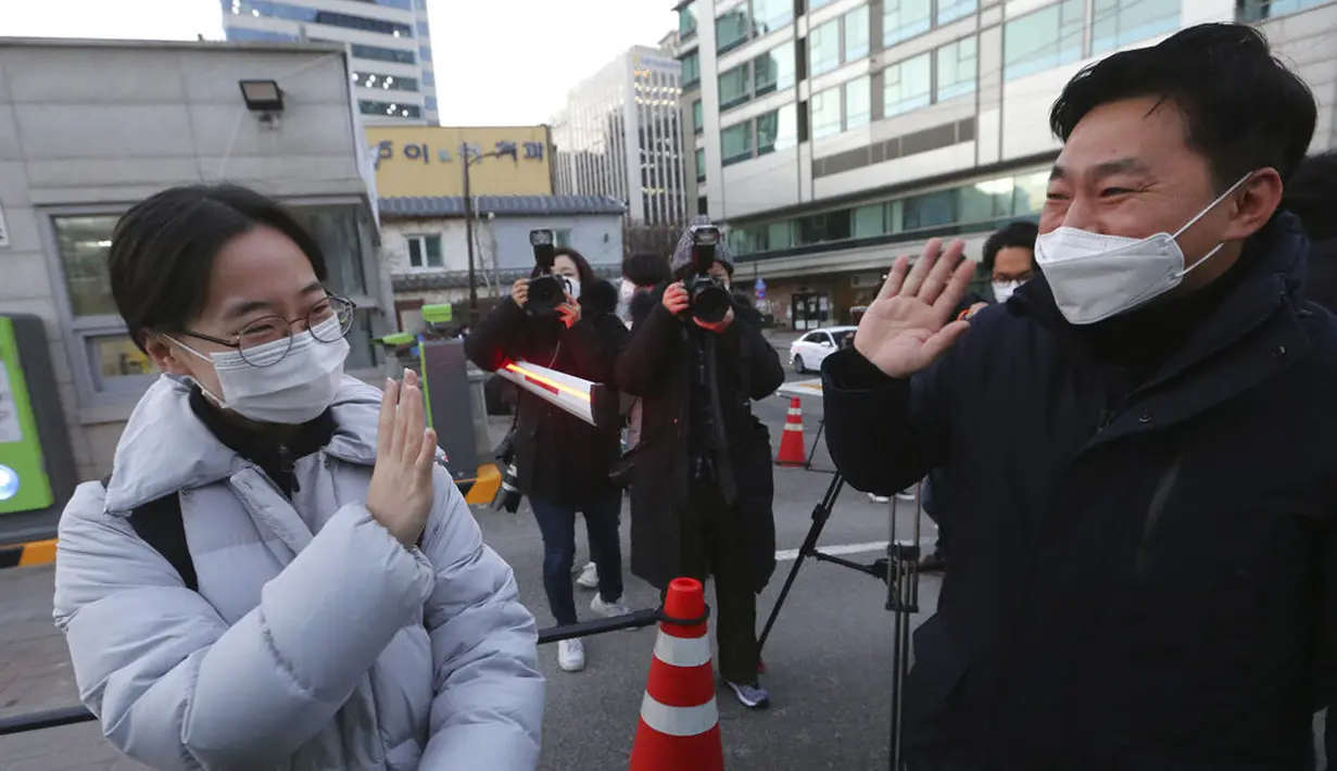 Seorang siswa melambai kepada ayahnya sebelum memasuki sekolah menengah untuk mengikuti ujian masuk perguruan tinggi di Seoul, Korea Selatan, Kamis (3/12/2020). Pejabat Korea Selatan mendesak orang-orang untuk tetap di rumah selama ujian masuk perguruan tinggi. (AP Photo/Ahn Young-joon)