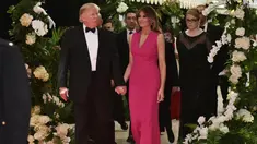 Melania Trump mendampingi Donald Trump saat menghadiri gala tahunan Palang Merah Amerika ke-60 di Mar-a-Lago, Florida, AS (4/2). First Lady Melania Trump tampil anggun dengan mengenakan gaun berwarna merah muda. (AFP/Mandel Ngan)