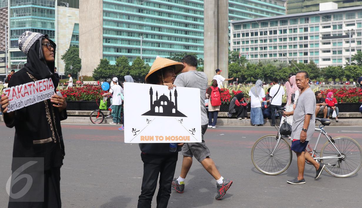 Aktivis dari Dompet Dhuafa melakukan sosialisasi saat Hari Bebas Kendaraan Bermotor (HBKB) di kawasan M.H Thamrin, Jakarta, (29/5/2016). Sosialisasi tersebut dilakukan untuk mengajak masyarakat akan pentingnya berzakat.(Liputan6.com/ Herman Zakharia)