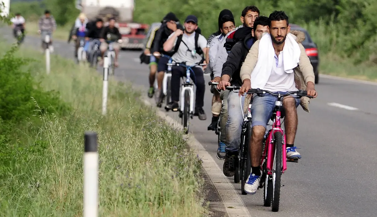 Sejumlah imigran dari Suriah menaiki sepeda di dekat perbatasan Yunani di Makedonia, Rabu (17/6/2015). Mereka mencari perlindungan dengan menempuh ribuan kilometer. (REUTERS/Ognen Teofilovski)