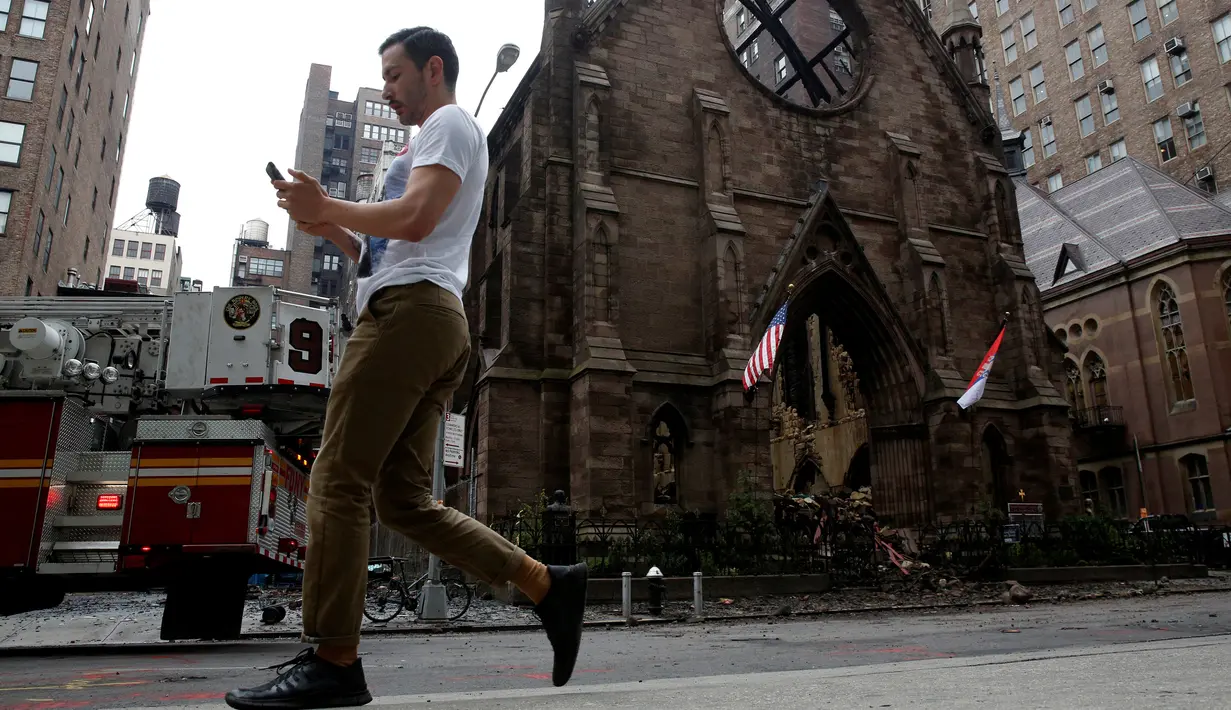 Pejalan kaki melintas di depan Gereja Katedral Ortodoks Serbia dari Saint Sava di Manhattan, New York, Senin (2/5). Gereja berusia 160 tahun itu dilalap api pada Minggu, 1 Mei 2016, beberapa saat setelah umat merayakan Paskah. (REUTERS/Brendan McDermid)