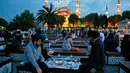 Sejumlah warga bersiap menikmati menu berbuka puasa di Sultanahmet Square, Istanbul, 27 Mei 2017. Saat tiba waktu Maghrib yang sekaligus menjadi penanda waktu berbuka puasa di Ibu kota Turki, ditandai dengan tembakan meriam. (AP Photo/Lefteris Pitarakis)