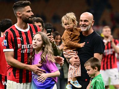 Penyerang AC Milan #09 Olivier Giroud dan putrinya Jade merayakan di samping pelatih AC Milan Stefano Pioli dan kerabatnya pada akhir pertandingan terakhir mereka saat melawan Salernitana dalam matchday terakhir Serie A di San Siro, Minggu (26/5/2024) dini hari WIB. (MARCO BERTORELLO / AFP)