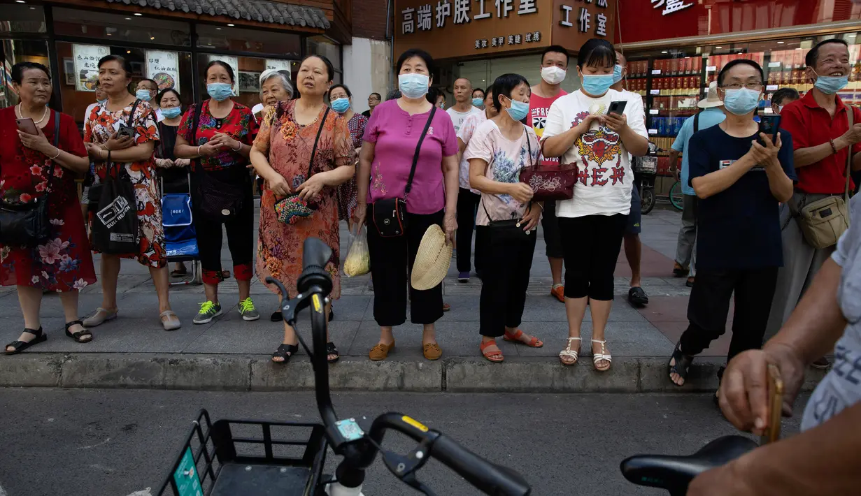 Orang-orang berkumpul ketika pihak berwenang China bersiap untuk memasuki Konsulat Amerika Serikat (AS) di Chengdu, Senin (27/7/2020). Bendera Amerika Serikat di Konsulat AS Chengdu diturunkan Senin (27/7), menandai ditutupnya kantor perwakilan Negeri Paman Sam di kota itu. (AP Photo/Ng Han Guan)