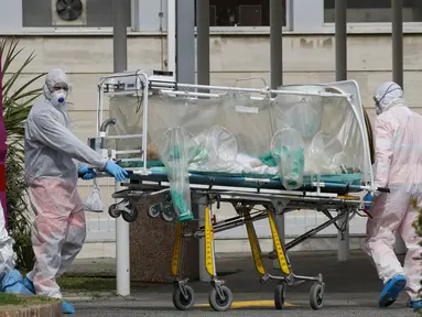 Petugas medis membawa pasien dari ambulans yang tiba di Rumah Sakit Columbus Covid 2 di Roma, Italia, Selasa (17/3/2020). Hingga Jumat (20/3/2020), jumlah kasus virus corona COVID-19 di Italia sudah mencapai 41.035 dengan total kematian sebanyak 3.405 orang. (AP Photo/Alessandra Tarantino)