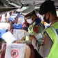 Polisi memeriksa dokumen penumpang bus yang keluar Tol Merak, Banten, Senin (18/5/2020). Pemeriksaan (check point) tersebut terkait larangan mudik guna penyekatan atau memeriksa kemungkinan pemudik yang akan keluar dari wilayah Jabodetabek. (Liputan6.com/Angga Yuniar)