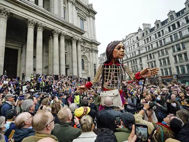 Boneka raksasa Little Amal disambut ratusan warga saat tiba di kota London, Inggris, Sabtu (23/10/2021). Little Amal merupakan boneka berukuran raksasa yang menjadi simbol pengungsi anak dari Suriah.(Aaron Chown/PA via AP)