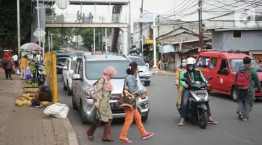 Pejalan kaki menyeberangi jalan di depan Stasiun Lenteng Agung, Jakarta, Senin (4/11/2019). Meski telah tersedia JPO, sebagian pejalan kaki lebih memilih untuk menyeberang sembarangan sehingga mengganggu arus lalu lintas serta berpotensi menimbulkan kecelakaan. (Liputan6.com/Immanuel Antonius)