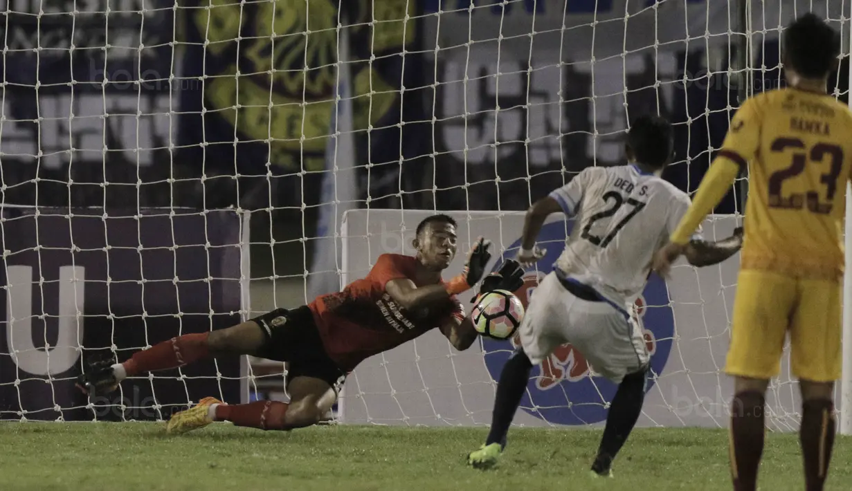 Kiper Sriwijaya FC, Teja Paku Alam, berhasil menghalau bola tendangan penalti Dedik Setiawan pada laga perempat final Piala Presiden di Stadion Manahan, Solo, Minggu, (4/2/2018). Sriwijaya FC menang 3-1 atas Arema FC. (Bola.com/M Iqbal Ichsan)