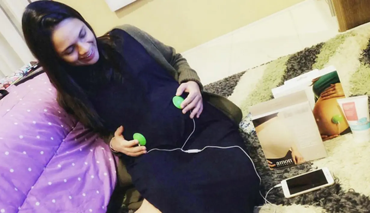 Presenter, yang juga dokter Nycta Gina sedang menyetel musik untuk didengarkan pada calon buah hatinya. Ia menempelkan pada perutnya yang mulai besar.(foto: instagram/missnyctagina)