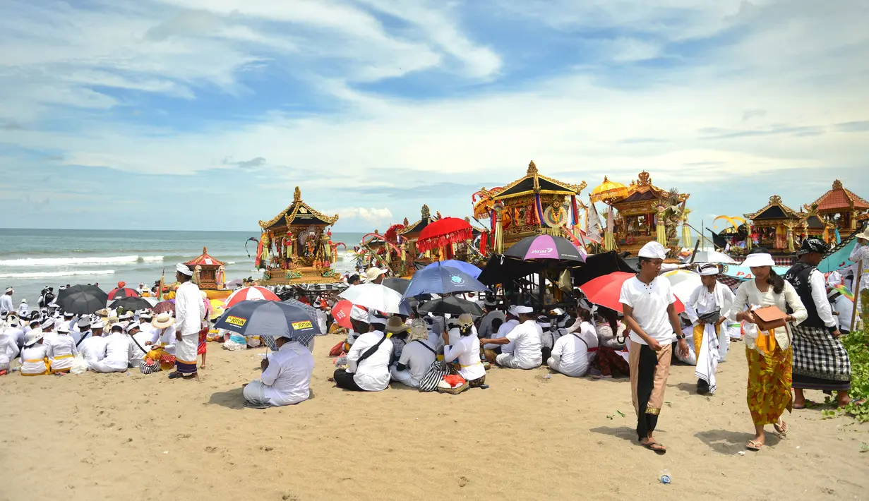 Umat Hindu Bali melakukan upacara Melasti di pantai Petitenget, Bali, Rabu (14/3). Sebelum Hari Raya Nyepi, masyarakat Bali yang beragama Hindu melakukan upacara Melasti ke laut. (AFP Photo/Sonny Tumbelaka)