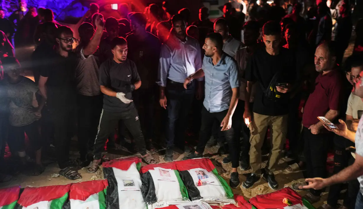 Warga Palestina berkumpul mengelilingi jenazah warga Palestina yang tewas dalam serangan Israel selama perang dengan Hamas setelah ditemukan dari bawah reruntuhan bangunan. Jenazah yang dibungkus bendera Palestina tersebut diiringi warga dalam prosesi pemakaman di Kota Gaza, Rabu (30/9/2026). Prosesi berlangsung dalam suasana duka, dengan keluarga dan warga setempat berkumpul untuk memberikan penghormatan terakhir kepada para korban. (AP Photo/Jehad Alshrafi)