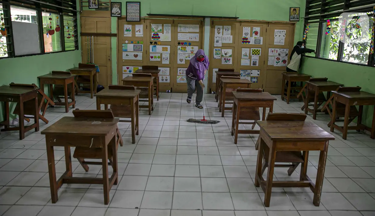 Sejumlah guru membersihkan kelas yang akan digunakan di SDN Kenari 08, Jakarta, Selasa (6/4/2021). Skema yang akan diterapkan adalah pembelajaran tatap muka secara bergantian dengan maksimum 50 persen dari kapasitas ruangan. (Liputan6.com/Faizal Fanani)