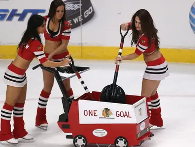 Ice Girls dari Chicago Blackhawks selain menghibur dengan tarian mereka bertugas membersihkan lapangan hoki es sebelum pertandingan National Hockey League (NHL) dimulai. (Jonathan Daniel/Getty Images/AFP)