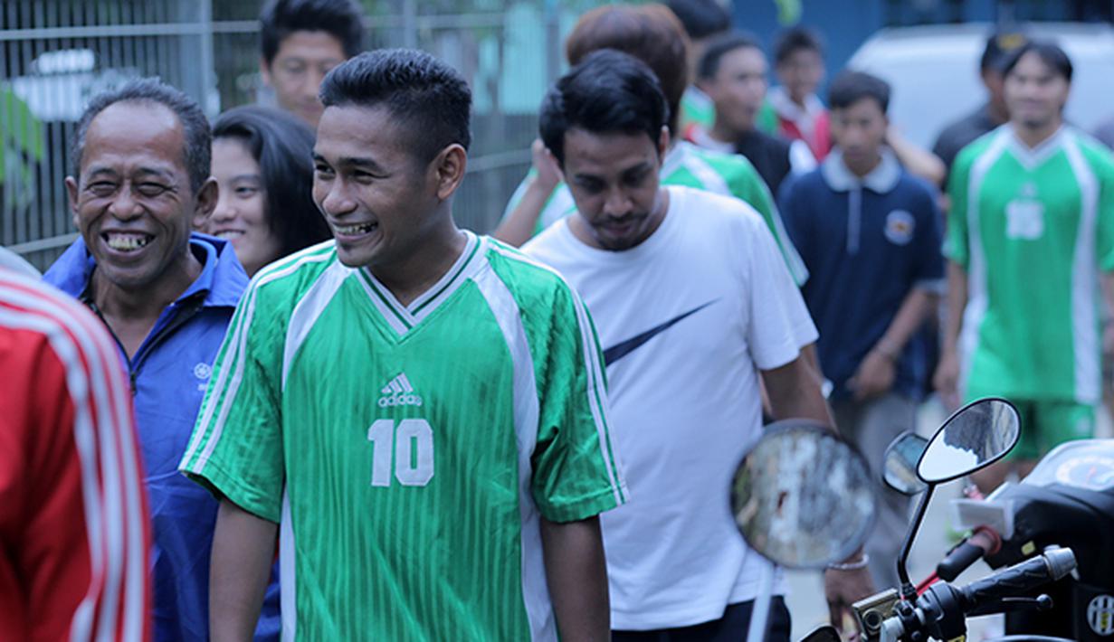 Ramdani Lestaluhu bersenda gurau dengan warga sekitar sebelum memasuki lapangan pertandinga. (Bola.com/Peksi Cahyo)