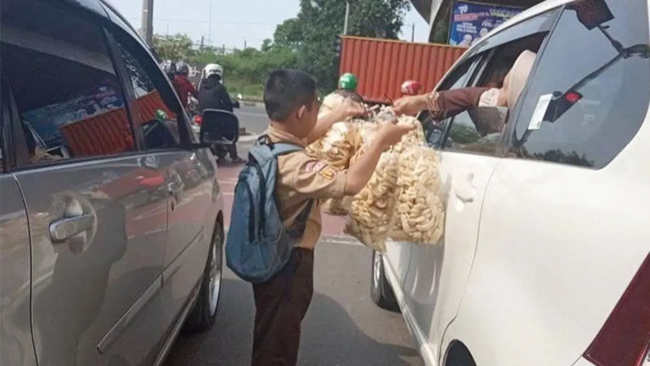 Demi Masa Depan, Bocah Berseragam Sekolah Nyambi Jualan di Lampu Merah