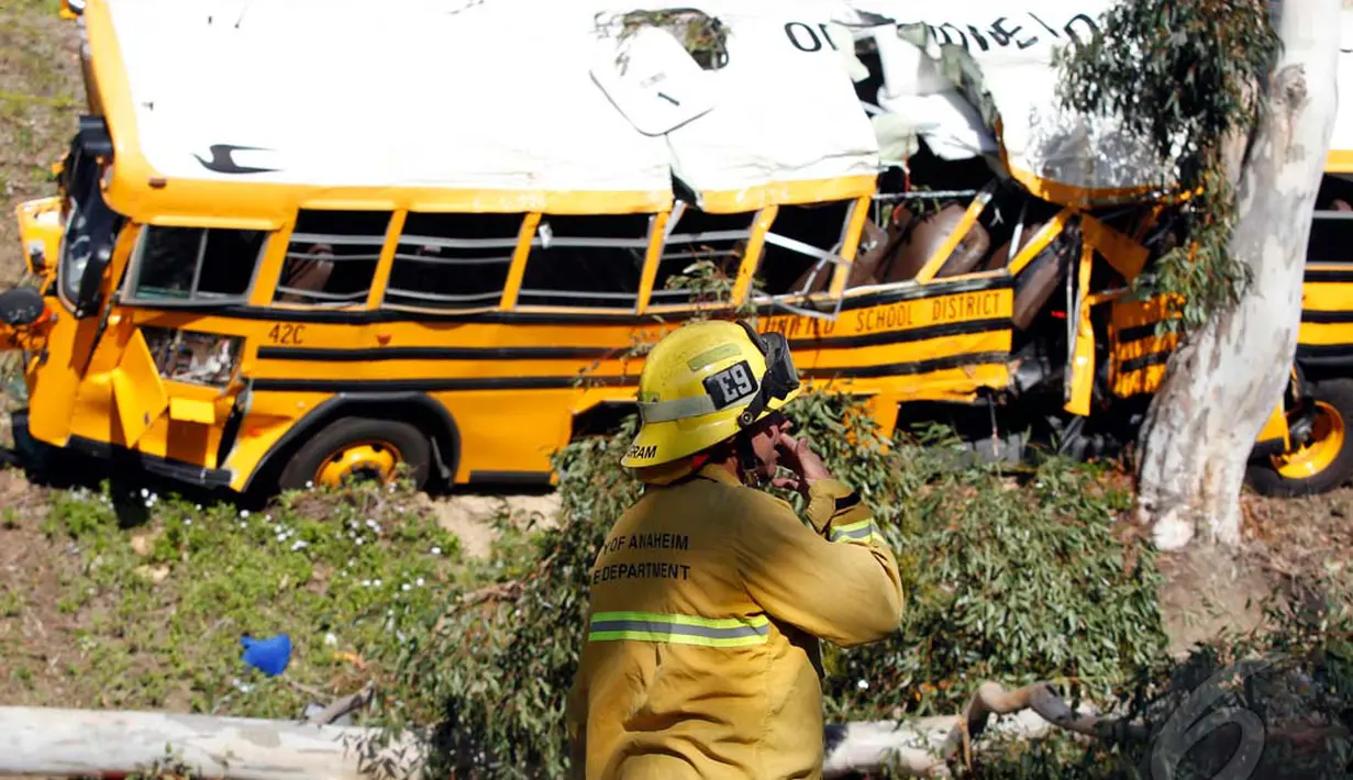  Petugas sedang memantau bus sekolah yang ringsek akibat menabrak pohon, Anaheim, California, Kamis (24/04/2014)(REUTERS/Alex Gallardo).