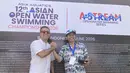 Executive Director Asia Aquatics Farid Fattahian (kanan) saat memberikan medali kepada Ketua Harian PB Akuatik Indonesia Harlin E. Rahardjo saat 12th Asian Open Water Swimming Championship 2026 di Pantai Jimbaran pada Minggu (14/6/2026). (Bola.com/Alit Binawan)