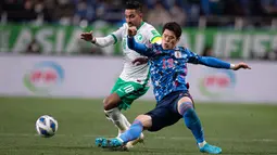 Pemain Jepang Hiroki Sakai (kanan) berebut bola dengan pemain Arab Saudi Salem al-Dawsari dalam laga kualifikasi Piala Dunia zona Asia Grup B di Saitama Stadium, Saitama, Jepang, Selasa (1/2/2022). Jepang menang dengan skor 2-0. (AFP/Philip Fong)