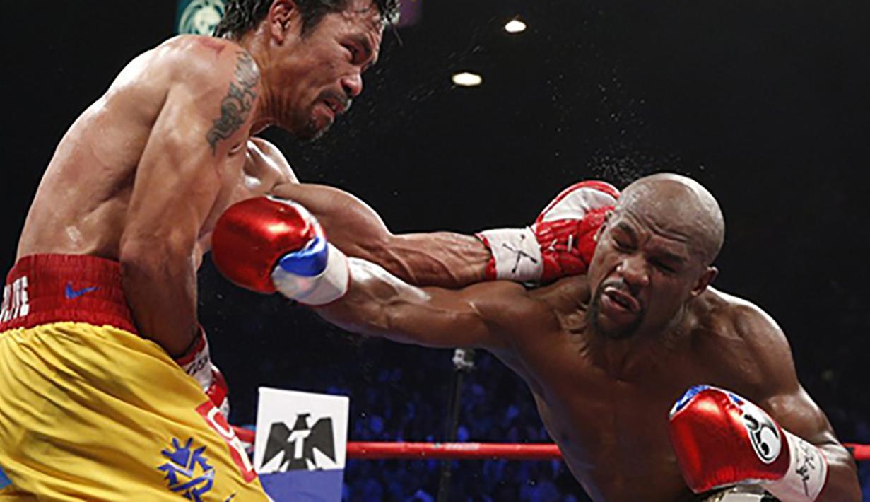 Aksi Floyd Mayweather Jr. saat mengalahkan Manny Pacquiao di MGM Grand Garden Arena, AS, Sabtu (2/5/2015). Menurut data media Forbes setiap tahun Mayweather membukukan penghasilan sebesar 300 miliar dollar AS. (AFP Photo/John Gurzinksi)