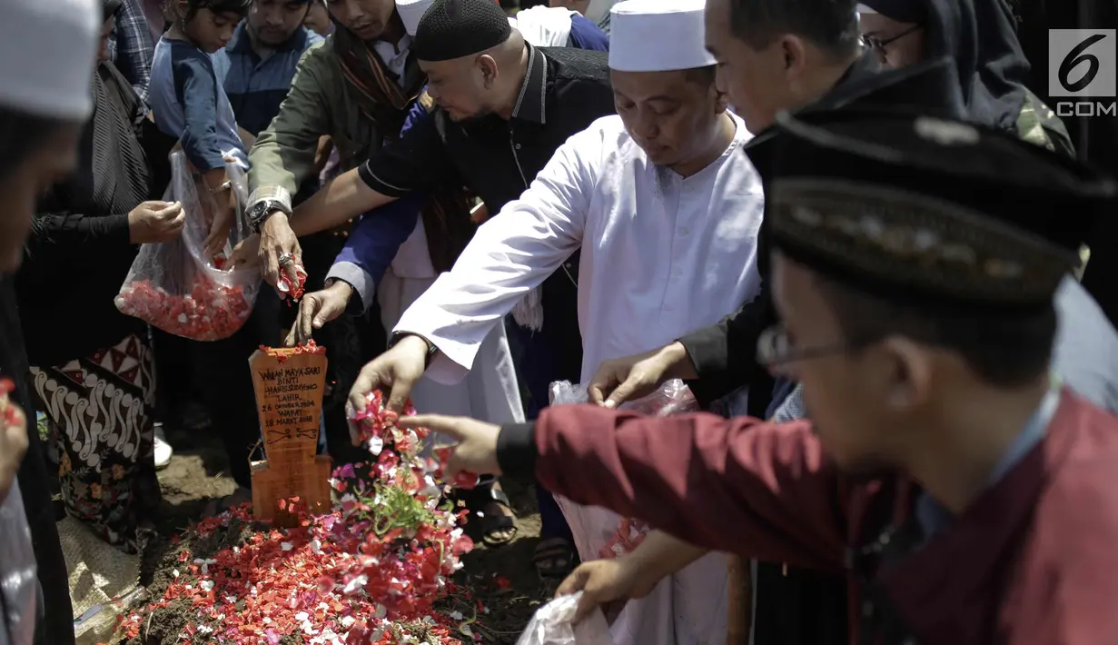 Penyanyi religi Opick menaburkan bunga usai memakamkan almarhum istri keduanya Wulan Mayasari di TPU Semper, Jakarta, Senin (19/3). Diiringi shalawat nabi dan tahlil, Opick memakamkan istrinya dengan wajah yang tegar. (Liputan6.com/Faizal Fanani)