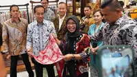 Presiden Joko Widodo atau Jokowi lirik produk milik Nasabah Permodalan Nasional Madani (PNM), Erawati atau akrab dipanggil Era, di Gelar Batik Nusantara (GBN) 2023