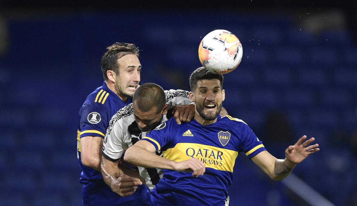 Penyerang Boca Juniors, Lisandro Lopez, berebut bola dengan bek Libertad, Paulo Da Silva, pada laga grup H Copa Libertadores di Estadio La Bombonera, Rabu (30/9/2020) dini hari WIB. Boca Juniors bermain imbang 0-0 atas Libertad. (Juan Mabromata/Pool via AP)