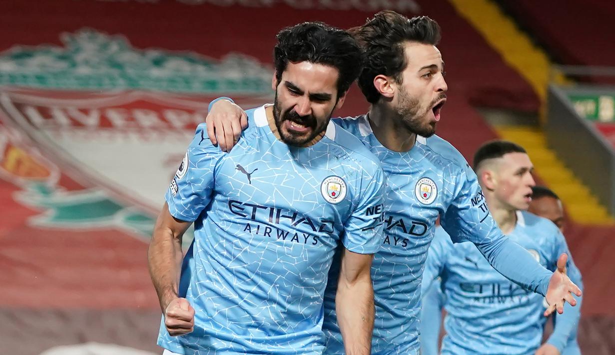 Gelandang Manchester City, Ilkay Gundogan (kiri) melakukan selebrasi bersama Bernardo Silva usai mencetak gol pertama timnya ke gawang Liverpool dalam laga lanjutan Liga Inggris 2020/21 pekan ke-23 di Anfield Stadium, Minggu (7/2/2021). Manchester City menang 4-1 atas Liverpool. (AFP/Jon Super/Pool)
