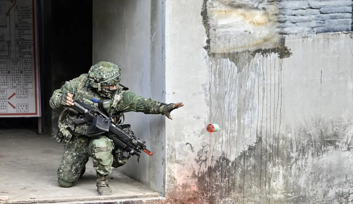 Seorang tentara Taiwan melemparkan bom asap saat demonstrasi di sebuah pangkalan militer di Kaohsiung, Taiwan, 6 Januari 2022. Militer Taiwan menggelar latihan tempur darat, laut, dan udara di tengah ketegangan dengan China. (Sam Yeh/AFP)