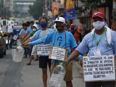 Pengemudi jeepney dengan poster “Bu / Pak, kami pengemudi jeepney, mohon bantuannya”, di sepanjang jalan di Manila, 12 Agustus 2020. Angkutan ikonik di Filipina itu belum dapat mengangkut penumpang sejak Maret akibat lockdown Covid-19 yang membuat jutaan orang kehilangan pekerjaan. (Ted ALJIBE/AFP)