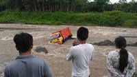 Sebuah truk terjebak banjir dan dihanyutkan arus sungai Pabelan yang sedang Banjir Lahar dingin. (foto : Liputan6.com / Edhie Prayitno Ige)