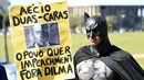 Seorang aktivis mengenakan kostum superhero Batman turun ke jalan memprotes Presiden Brasil Dilma Rousseff di Gedung Kongres Nasional, Brasil (27/5/2015). Aktivis ini menuntut keadilan terkait kebijakan pemotongan anggaran. (AFP PHOTO/EVARISTO SA)