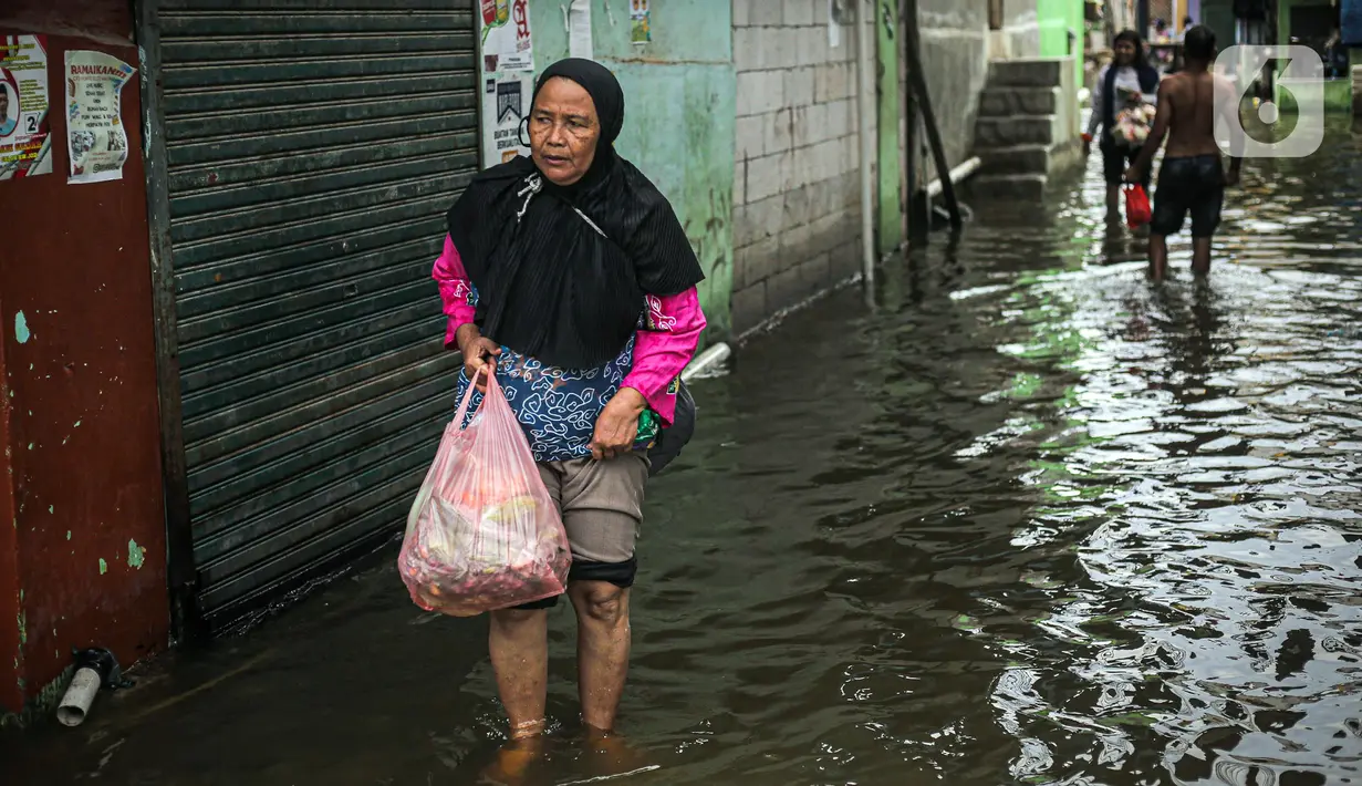 Warga beraktivitas saat banjir rob di Muara Angke, Jakarta, Jumat (25/11/2022). Badan Penanggulangan Bencana Daerah (BPBD) DKI Jakarta mengimbau agar warga di pesisir Jakarta mengantisipasi banjir pesisir atau rob selama 22-28 November 2022. (Liputan6.com/Faizal Fanani)