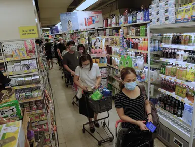 Orang-orang membeli makanan di supermarket untuk persiapan menghadapi Badai Tropis Kompasu di Hong Kong pada Selasa (12/10/2021). Observatorium Hong Kong mengeluarkan sinyal nomor 8, level tertinggi ketiga dalam skalanya, saat siklon tropis Kompasu semakin mendekati kota. (AP Photo/Vincent Yu)
