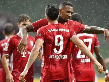 Striker Bayern Munchen, Robert Lewandowski, melakukan selebrasi bersama Jerome Boateng usai membobol gawang Werder Bremen pada laga Bundesliga di Weserstadion, Bremen, Selasa (16/6/2020). Bayern Munchen menang dengan skor 1-0 atas Werder Bremen. (AP/Martin Meissner)