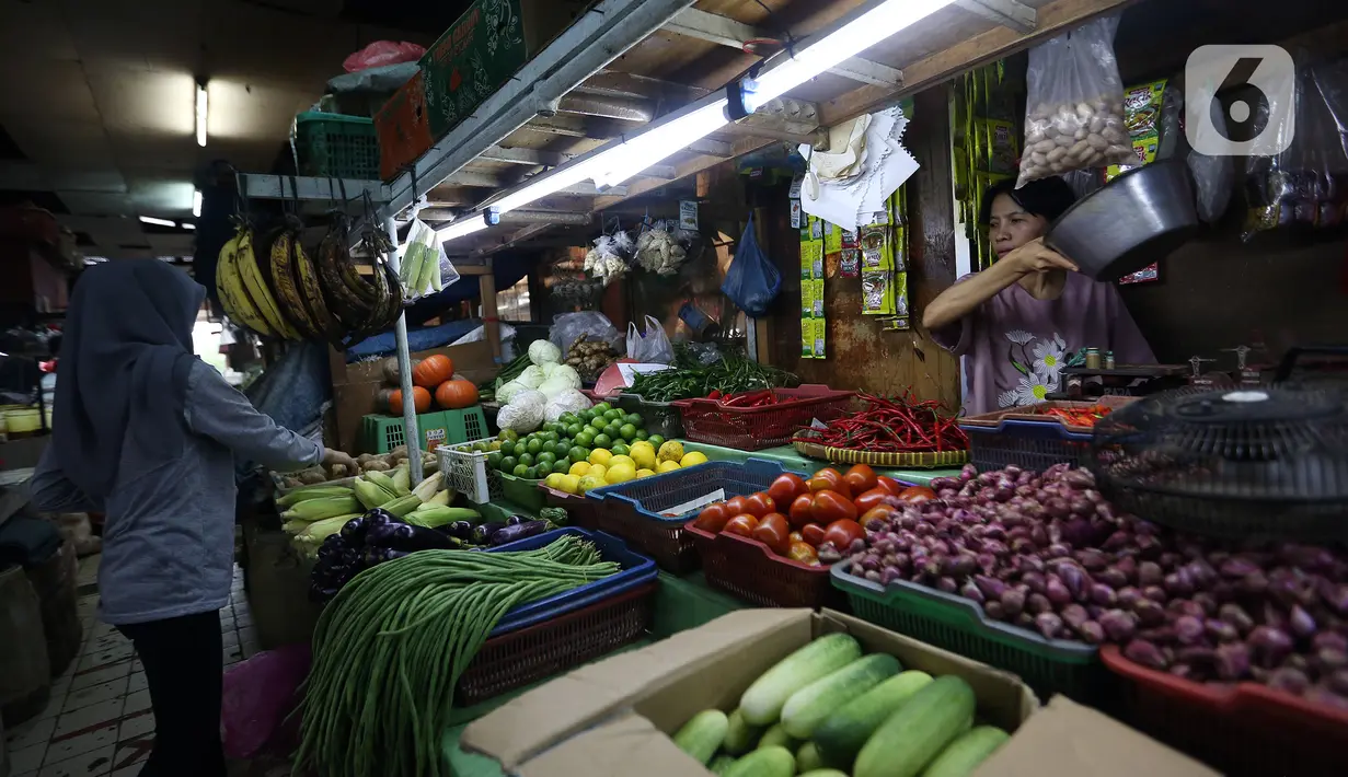 Wahyuning (kanan) melayani pembeli kebutuhan pokok dagangannya di Pasar Pondok Labu, Jakarta, Rabu, (8/6/2022). Wahyuning menjelaskan harga cabai merah tembus Rp 80.000 per kilogram dari yang sebelumnya Rp 40.000, diikuti cabai rawit dan bawang merah. (Liputan6.com/Johan Tallo)