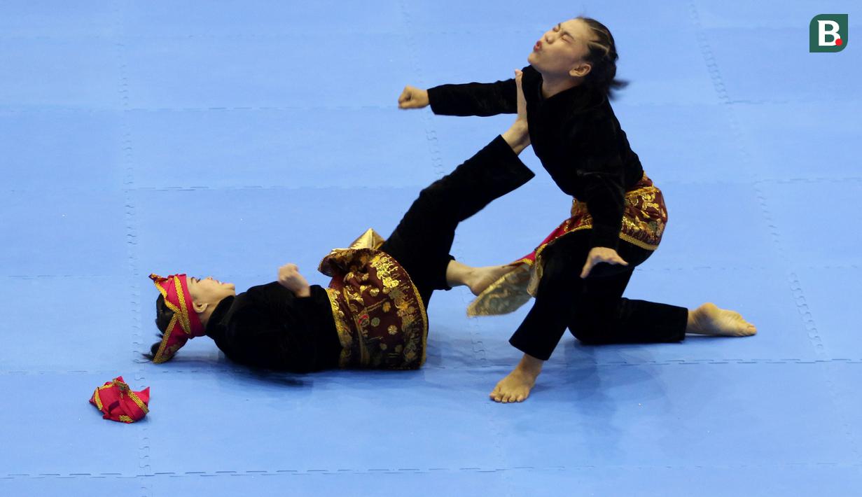 Pesilat Indonesia Riska Hermawan (kiri) dan Ririn Rinasih saat bertanding dalam nomor Seni Ganda Wanita Pencak Silat Sea Games 2021 Vietnam di Bac tu Liem Sport Center, Hanoi, Rabu (11/5/2022). (Bola.com/Ikhwan Yanuar)