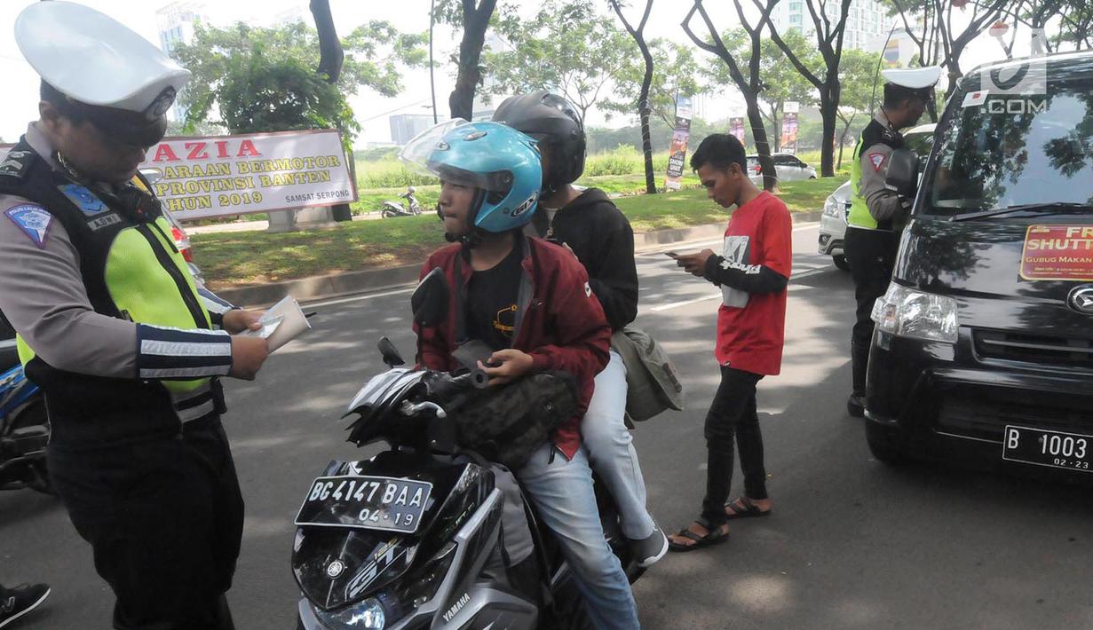 Anggota Satlantas Polres Tangerang Selatan memeriksa kelengkapan surat saat razia pajak kendaraan di Jalan BSD, Tangerang Selatan, Kamis (24/1). Razia juga untuk meningkatkan tertib lalu lintas dan disiplin pengendara bermotor. (Merdeka.com/Arie Basuki)