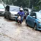 Pengendara motor melintas di antara mobil yang terjebak kemacetan saat banjir di Jalan Lapangan Banteng Utara, Jakarta, Kamis (15/2). Hujan deras yang mengguyur dan buruknya drainase menyebabkan kawasan tersebut banjir (Liputan6.com/Immanuel Antonius)