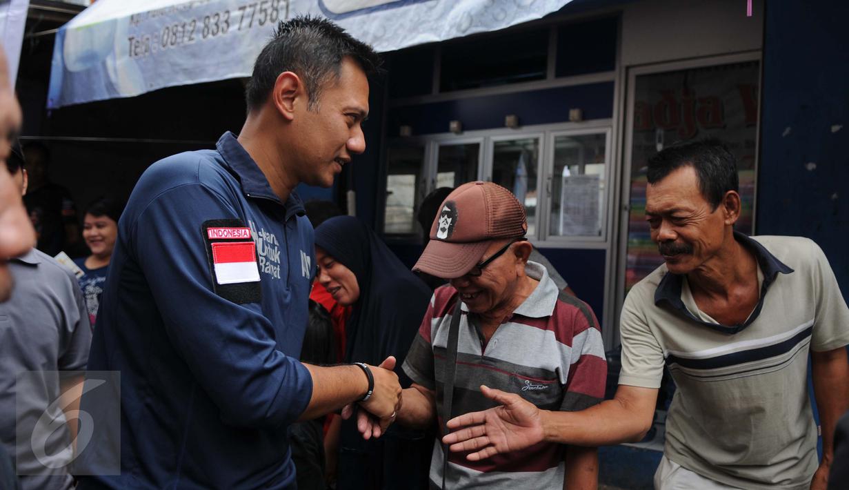 Cagub DKI Jakarta, Agus Harimurti Yudhoyono  menyalami warga saat blusukan di kawasan Kampung Pulo, Jakarta, Selasa (27/12). Dalam Kampanyenya AHY berjanji untuk mengurangi jumlah pengangguran dan penciptaan lapangan kerja. (Liputan6.com/Gempur M Surya)