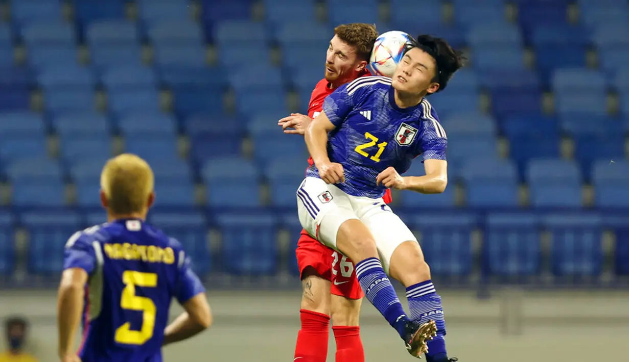 Pemain Kanada Joel Waterman (kiri) dan pemain Jepang Ayase Ueda melompat untuk berebut bola udara pada pertandingan persahabatan di Dubai, 17 November 2022. Kanada mengalahkan Jepang dengan skor 2-1. (AP Photo/Christopher Pike)