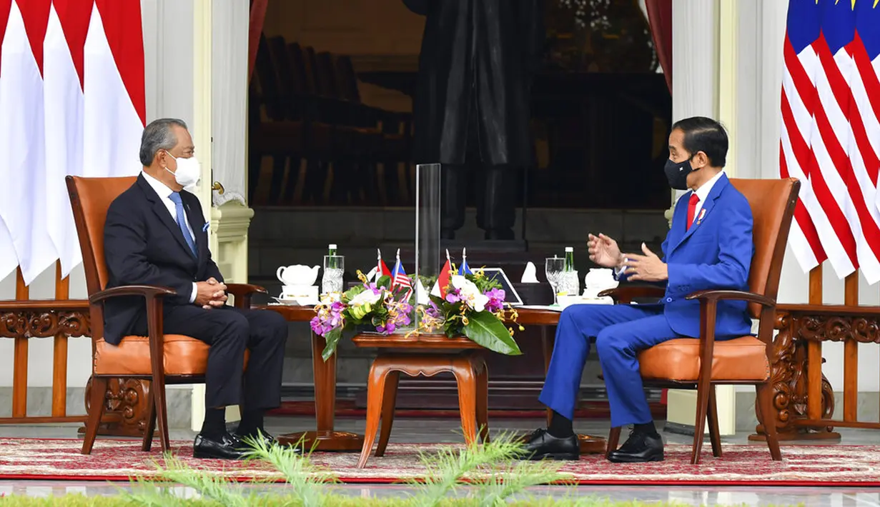 Presiden Indonesia Joko Widodo (kanan) berbincang dengan Perdana Menteri Malaysia Muhyiddin Yassin saat bertemu di Istana Merdeka, Jakarta, Jumat (5/2/2021). Baik Jokowi maupun Muhyiddin Yasin terlihat sama-sama mengenakan masker. (Agus Suparto, Indonesian President Palace via AP)