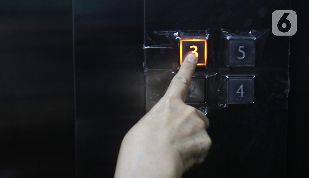 Seseorang menekan tombol lift yang sudah dilapisi isolasi bening di PMI DKI Jakarta, Jumat (20/3/2020). PMI DKI Jakarta memberlakukan disiplin saling menjaga jarak atau social distancing agar kegiatan donor darah tetap aman dan terhindar dari penularan COVID-19. (Liputan6.com/Herman Zakharia)
