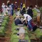 Sejumlah orang saat berziarah ke makam di Tempat Pemakaman Umum (TPU) Pondok Ranggon, Jakarta, Minggu (04/04/21). Meskipun di tengah pandemi Covid-19 warga tetap melakukan tradisi ziarah kubur. menjelang bulan Ramadan. (Liputan6.com/Faizal Fanani)