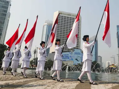 Sejumlah pasukan pengibar bendera (Paskibra) berbaris membawa bendera Merah Putih di Bundaran Hotel Indonesia (HI), Jakarta, Kamis (15/8/2024). (Liputan6.com/Herman Zakharia)