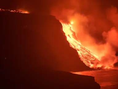 Lava dari gunung berapi mencapai laut di pulau Canary La Palma, Spanyol, Rabu (29/9/2021) dinihari. Lava merah panas dari gunung berapi Cumbre Vieja mencapai Samudra Atlantik, sembilan hari setelah mulai mengalir menuruni gunung. (AP Photo/Saul Santos)